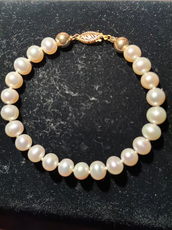 A 7mm.freshwater pearl and 14kt gold bracelet circ