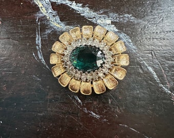 Floral rhinestone brooch with clear rhinestones around  emerald green center stone circa 1960s