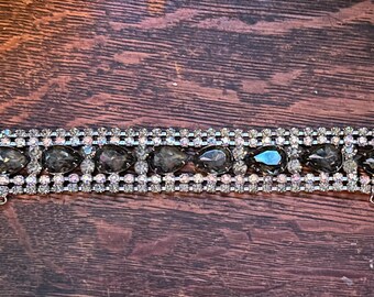 A rhinestone bracelet in aurora Borealis and grey topaz color stones circa 1950s