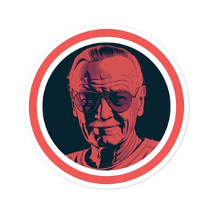 May include: A red and white circular sticker with a black and white illustration of Stan Lee wearing sunglasses. The background is black.