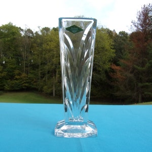May include: A clear glass vase with a diamond pattern and a green label that reads "Crystal by Waterford".