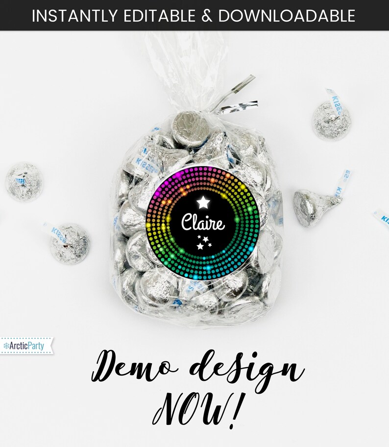 May include: A bag of silver foil-wrapped chocolate kisses with a round sticker on the front. The sticker has a black background with a rainbow circle of dots and a white star. The text "Claire" is written in white cursive font with three white stars below the name.