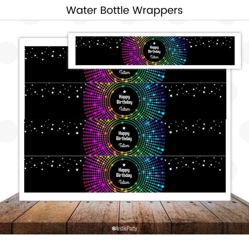May include: Water bottle wrappers with a black background and a rainbow circle design. The text "Happy Birthday Tatum" is in the center of the circle.