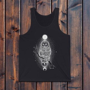 May include: Black tank top with a white graphic of an owl perched on a branch with a crescent moon and full moon above it. The text "Black Magic" is below the owl.