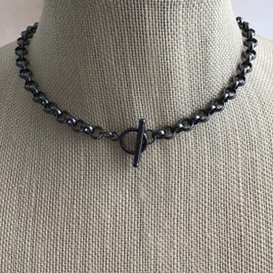 May include: A black chain necklace with a t-bar clasp.
