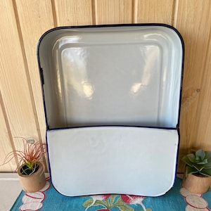 Puede incluir: Plato para hornear de esmalte blanco con borde azul. El plato tiene una sección extraíble que se puede utilizar como un recipiente separado.