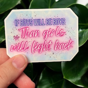 May include: A rectangular sticker with the text "If boys will be boys, Than girls will fight back" in purple and pink. The sticker has a light blue and white background with a floral design.