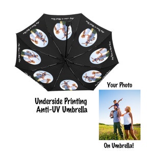 Puede incluir: Paraguas negro con una foto personalizada impresa en la parte inferior. La foto muestra una familia de tres, un niño que está siendo sostenido sobre los hombros de un adulto. El paraguas tiene el texto "Any Name on Wish Here" impreso en la tela.