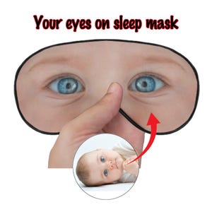 May include: Black sleep mask with a print of blue eyes and the text "Your eyes on sleep mask" in red. A small circular image of a baby with blue eyes is shown below the mask. The mask has a black border.