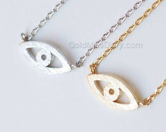 May include: Two delicate necklaces with a small eye charm pendant. One necklace is silver and the other is gold.