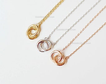 May include: Three gold, silver, and rose gold necklaces with a double circle pendant. Each necklace has a delicate chain.