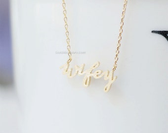 May include: A gold necklace with the word "wifey" written in cursive script.