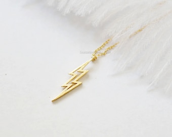 May include: A gold lightning bolt pendant necklace on a delicate chain. The pendant is a simple, modern design and would make a great gift for a friend or loved one.