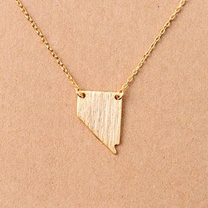 Puede incluir: Un collar de oro con un colgante con forma del estado de Nevada.