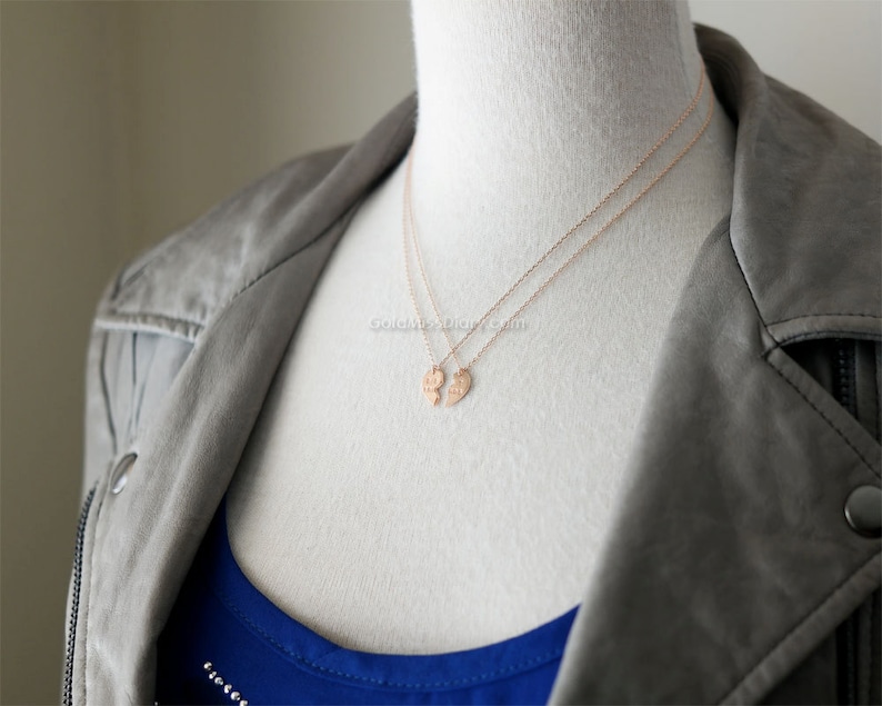 May include: Two gold necklaces with matching heart pendants. The pendants are split in half, with each half forming a complete heart when worn together.
