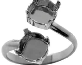 Könnte beinhalten: Ein silberner Ring mit zwei quadratischen Fassungen für Edelsteine. Der Ring ist so konzipiert, dass er am Knöchel des Fingers getragen wird.