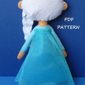 May include: A blue felt doll with white hair and a blue tulle skirt. The doll is wearing a blue dress and has a braid in her hair. The text "PDF PATTERN" is visible in the image.
