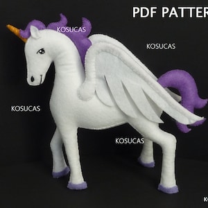 Peut inclure: Patron PDF pour une licorne en feutre blanc avec une crinière, une queue et des ailes violettes. La licorne a une corne dorée et des yeux noirs.