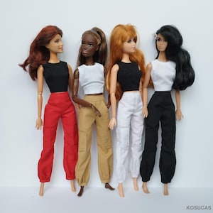 May include: Four fashion dolls are displayed, each with different skin tones and hairstyles. They are dressed in coordinated outfits: black or white tops paired with red, tan, white, and black cargo pants. The dolls stand against a plain background.