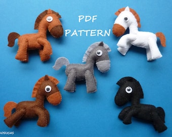 Puede incluir: Cinco patrones de caballos de fieltro en diferentes colores: marrón, blanco, gris, marrón y negro. Los patrones están dispuestos sobre un fondo azul. El texto "PDF PATTERN" está escrito en letras blancas sobre un fondo azul.