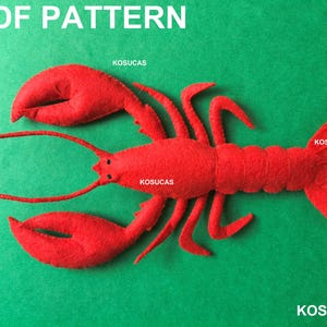 Puede incluir: Una langosta de fieltro rojo brillante para proyecto de manualidades con dos pinzas grandes, varias patas, antenas largas y cola segmentada. La imagen incluye el texto PDF PATTERN y KOSUCAS en blanco, indicando un patrón de costura digital.