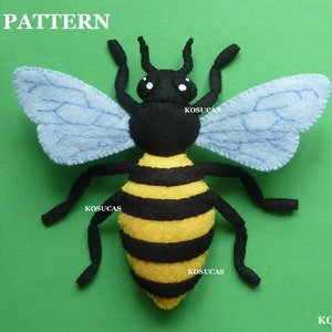 May include: A felt bee craft pattern, with black and yellow stripes, blue wings, and black legs. The pattern is labeled "PDF PATTERN" and "KOSUCAS".