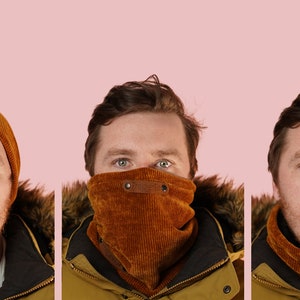 Puede incluir: Un hombre con un gorro de pana marrón y un pasamontañas de pana marrón. El pasamontañas tiene un cierre de botón.