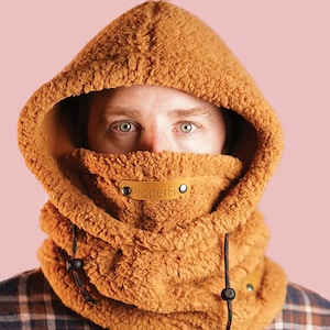 May include: A brown fleece hooded neck warmer with a black drawstring and a brown leather label that says "PaperFin".