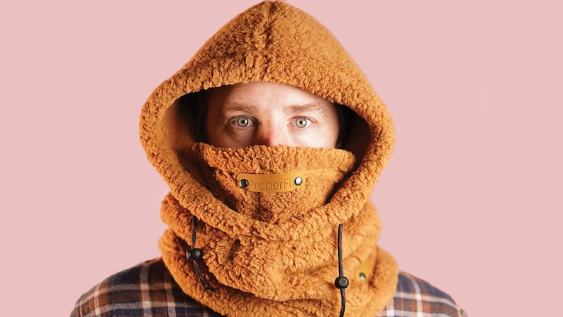 May include: A brown fleece hooded neck warmer with a black drawstring and a brown leather label that says "PaperFin".