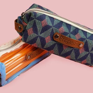 May include: Two pencil cases on a pink background. One is clear with orange pencils inside, the other is patterned with a geometric design in navy, teal, and coral. Both have zippers and the text "ProperFit".