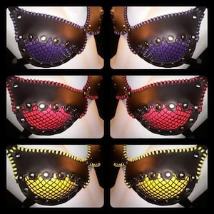 May include: Three pairs of black leather bras with different colored mesh inserts. The first pair has a purple mesh insert, the second pair has a red mesh insert, and the third pair has a yellow mesh insert.