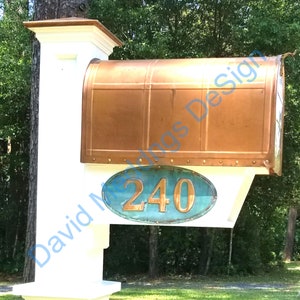 May include: White mailbox with a copper top and a blue and copper oval plaque with the number 240 on it.