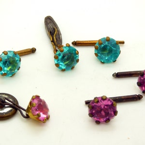 May include: Set of four cufflinks with turquoise and pink glass stones. The cufflinks have gold-tone metal settings and are in good condition.