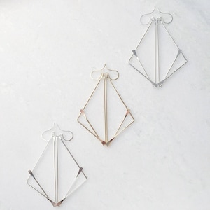 Sterling Silver and Gold Geometric "Fox" Earrings on white marble background. 
made by L.Greenwalt Jewelry of Portland, OR.