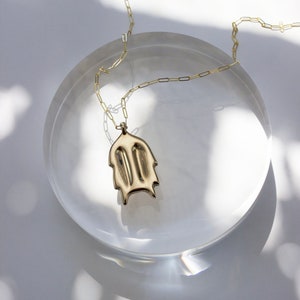 Gold Christmas Cactus Pendant Necklace on dappled white light background. 
made by L.Greenwalt Jewelry of Portland, OR.