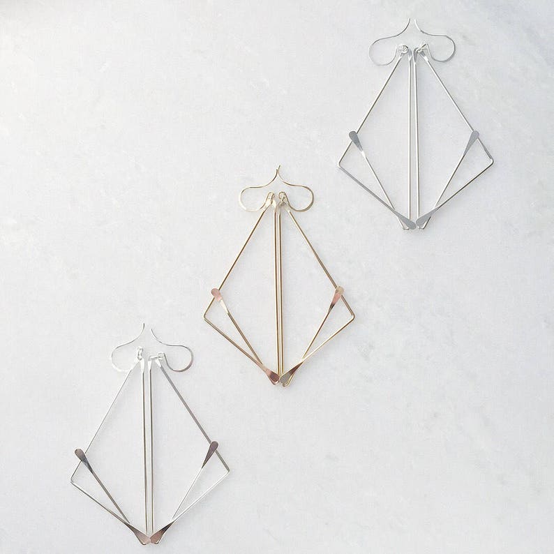 Sterling Silver and Gold Geometric "Fox" Earrings on white marble background. 
made by L.Greenwalt Jewelry of Portland, OR.