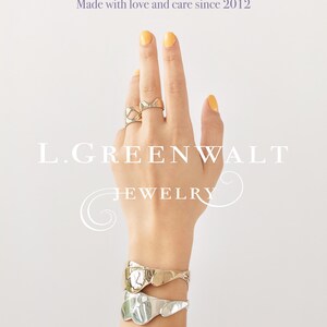 May include: A hand wearing gold and silver jewelry, including rings and bracelets. The image features the text "Thanks for your support" and "Made with love and care since 2012". The brand name "L. GREENWALT JEWELRY" is also visible.