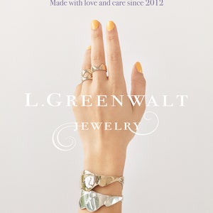 Puede incluir: Una mano de maniqu&iacute; con un brazalete de oro y plata y dos anillos de oro. La mano est&aacute; sobre un fondo blanco con el texto "L.GREENWALT JEWELRY" y "Thanks for your support. Made with love and care since 2012." El texto debajo de la mano dice "Free U.S priority mail shipping, Eco Friendly Packaging, Free U.S returns & exchanges, Always happy to help: chat with us here or via email, hello@lgreenwaltjewelry.com".