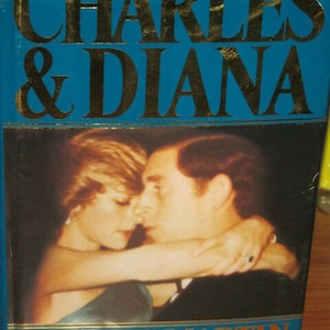 May include: A book cover with a photo of Prince Charles and Princess Diana embracing. The title is "Charles & Diana" in gold lettering on a blue background. The author is Ralph G. Martin, author of "Jennie".