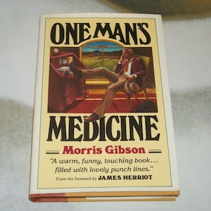 May include: A book cover with the title "One Man's Medicine" by Morris Gibson. The cover features a man sitting in a chair with a phone to his ear. The quote "A warm, funny, touching book... filled with lovely punch lines." is attributed to James Herriot.