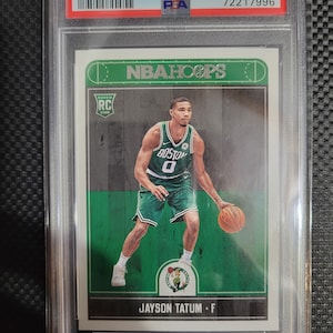 May include: A green and white basketball trading card featuring Jayson Tatum, a basketball player for the Boston Celtics. The card is from the 2017 Panini Hoops series and is numbered #253. The card is graded 9 by PSA.