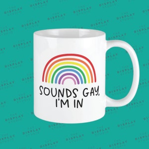 May include: White ceramic mug with a rainbow design and the text "SOUNDS GAY, I'M IN".