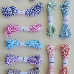 May include: Assortment of baker's twine in various colors and patterns, including red and white, green and white, blue and white, yellow and white, pink and white, teal and white, purple and white, orange and white, and brown and white. The twine is labeled "BC HANDS™".