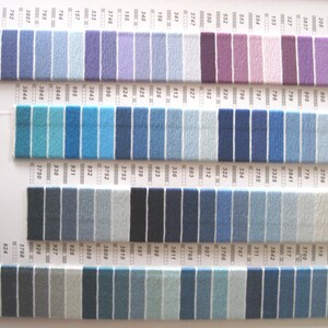 May include: A color chart of DMC embroidery floss with a variety of blue, purple, and gray shades. The chart is organized by color number and includes a total of 48 different colors.
