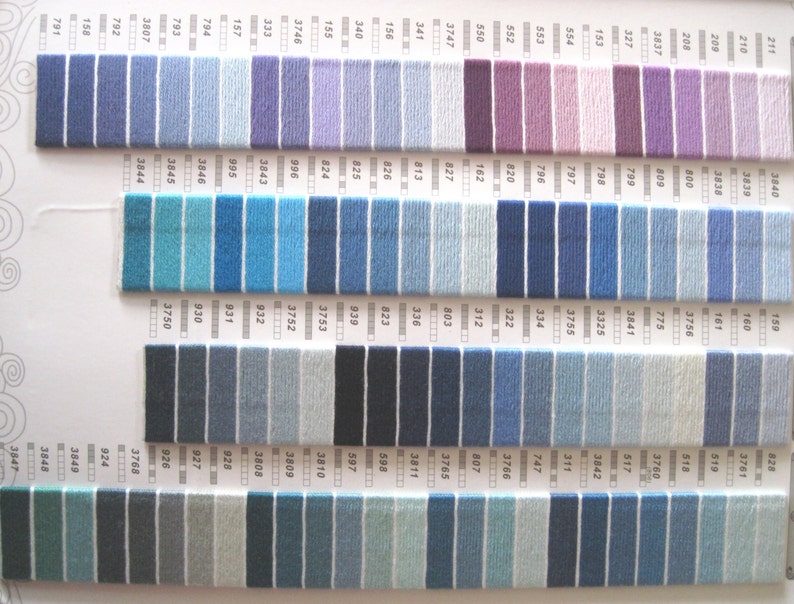 May include: A color chart of DMC embroidery floss with a variety of blue, purple, and gray shades. The chart is organized by color number and includes a total of 48 different colors.