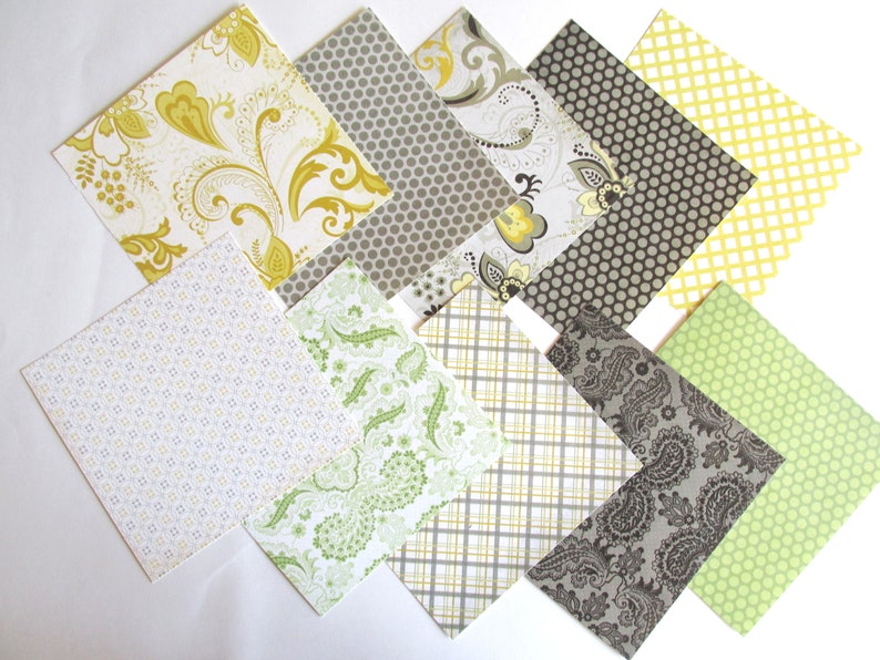 May include: Assortment of patterned scrapbook paper in various shades of green, yellow, and gray. The patterns include paisley, polka dots, and geometric designs.
