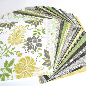 May include: A stack of patterned scrapbook paper in shades of green, yellow, and gray. The paper features various floral and geometric designs.