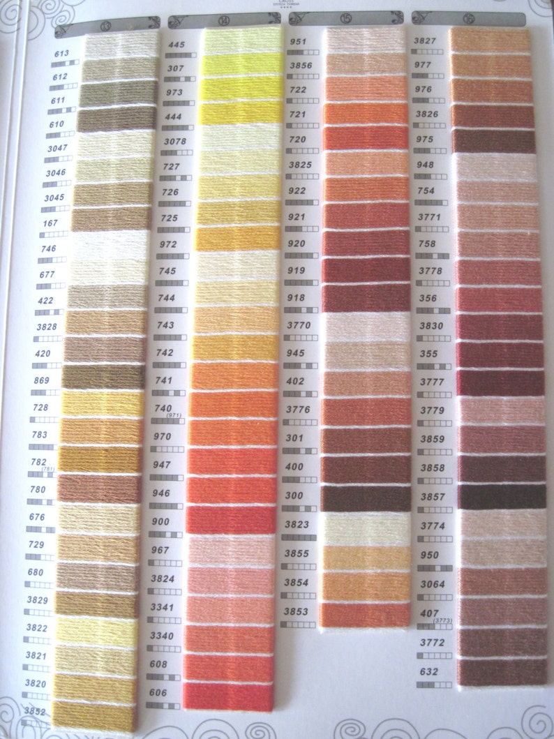 May include: A color chart of DMC embroidery floss with a variety of colors, including beige, brown, orange, red, pink, and white. The chart is organized by color number, with each color represented by a small skein of floss.