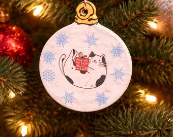 Ceramic  laying down cat ornament with snowflakes and present