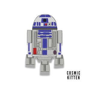 Puede incluir: Un parche bordado de R2-D2, un personaje robot de Star Wars. El parche es una representación de estilo de dibujos animados del robot con una cabeza redonda, un cuerpo rectangular y dos piernas.
